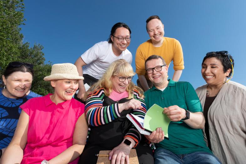 Hyväntuulisia opiskelijoita ryhmäkuvassa ulkona.