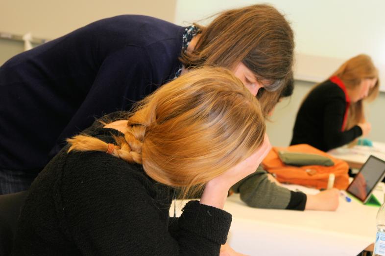 Opettaja auttaa opiskelijaa opetustilanteessa luokkahuoneessa