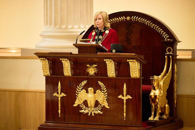 Rehtori Sari Lindblom yliopiston päärakennuksen juhlasalin puhujantuolissa.