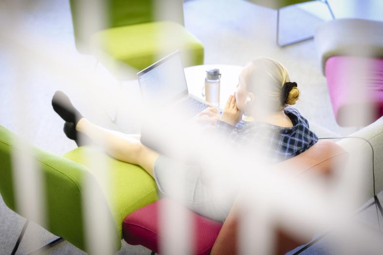 Person working on a latop and listening to an audio book