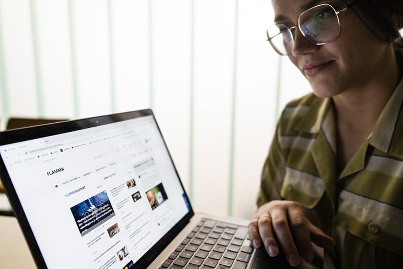 A member of the Uni community is browsing Flamma on a laptop.