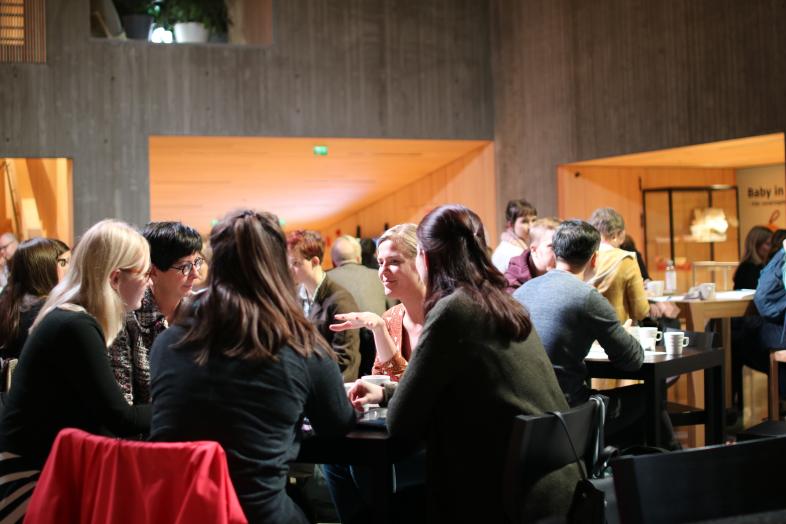 Mentorointiryhmä keskustelee pöydän ääressä. The mentoring group discusses around the table.