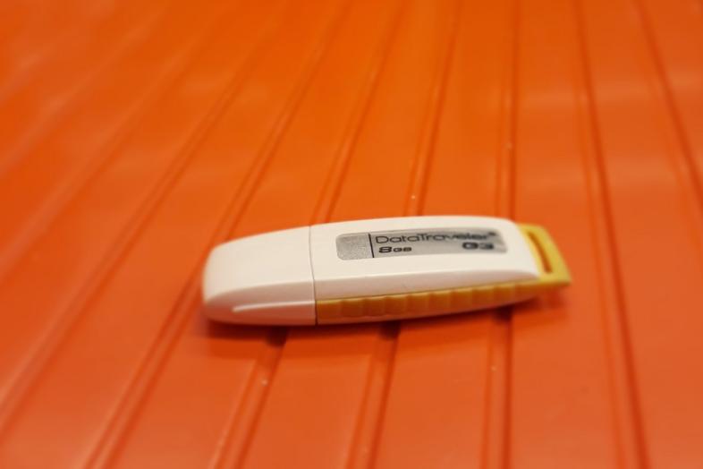 USB flash drive on the orange metro bench.