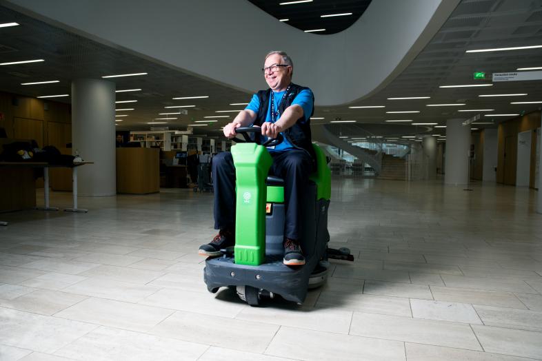 A cleaner driving a sweeper in the Kaisa House lobby.