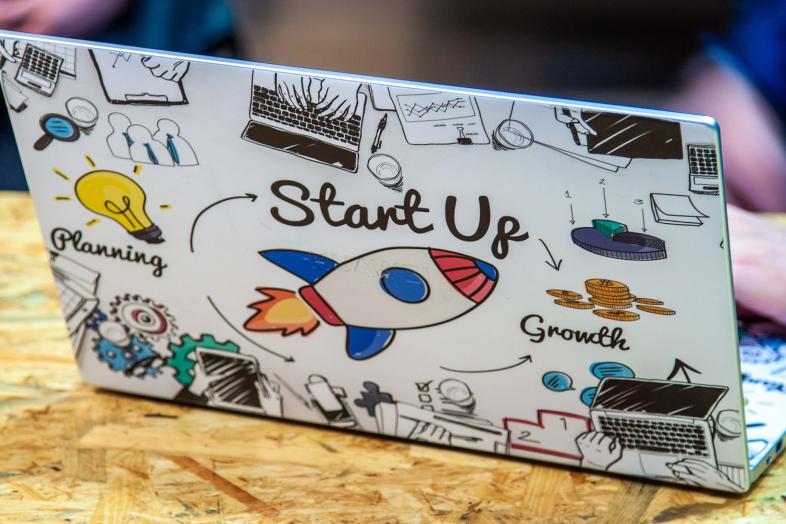 På baksidan av den bärbara datorn finns texten ”Start Up”.