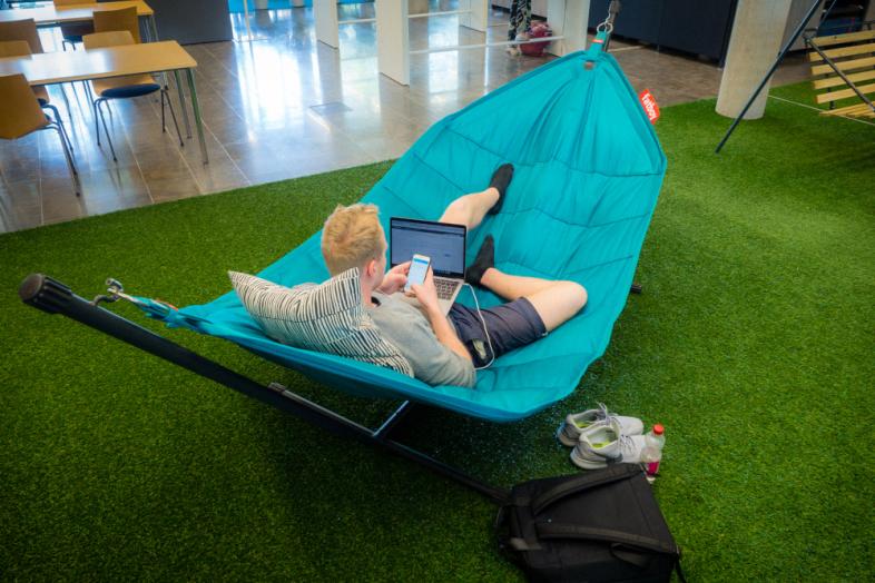 Student som studerar i hängmattan vid campusbiblioteket i Mejlans