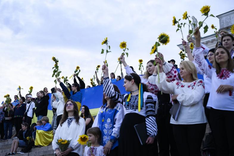 Ukrainska körer lyfter solrosor på trappan till katedralen.