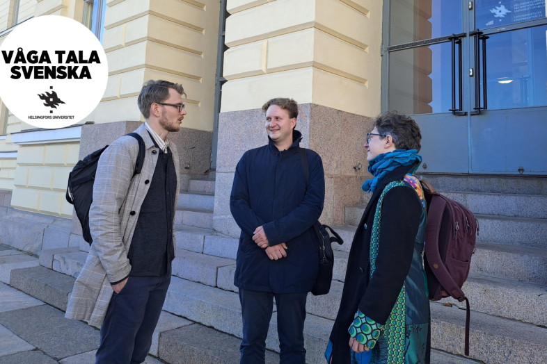 Helsingfors universitets personal och studenter talar utanför Huvudbyggnaden.