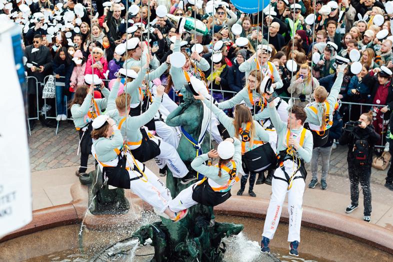 Student setting a graduate cap on the Havis Amanda statue.