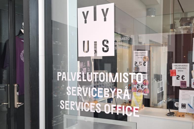 Lasiseinässä ylioppilaskunnan logo ja teksti "palvelutoimisto".