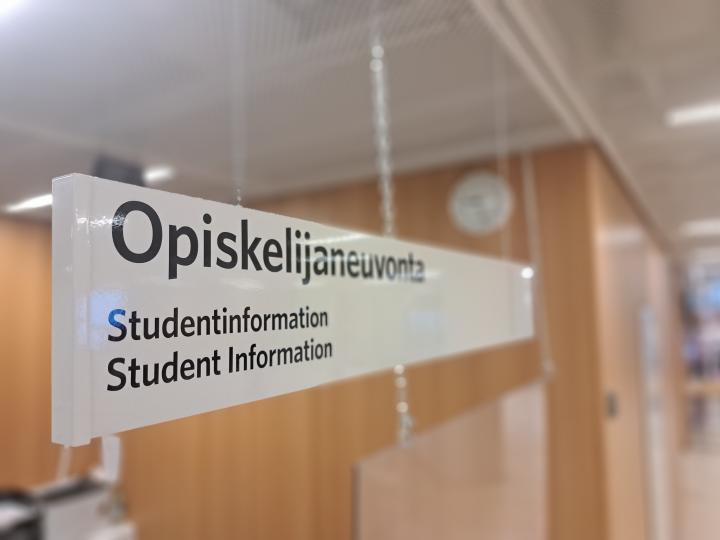 En vit skylt med texten "Studentinformation" på tre språk.