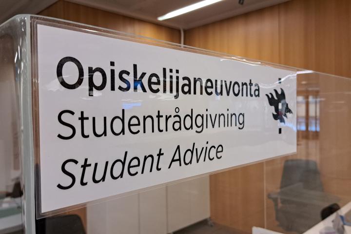 A white sign with the text "Student Advice" in three languages.